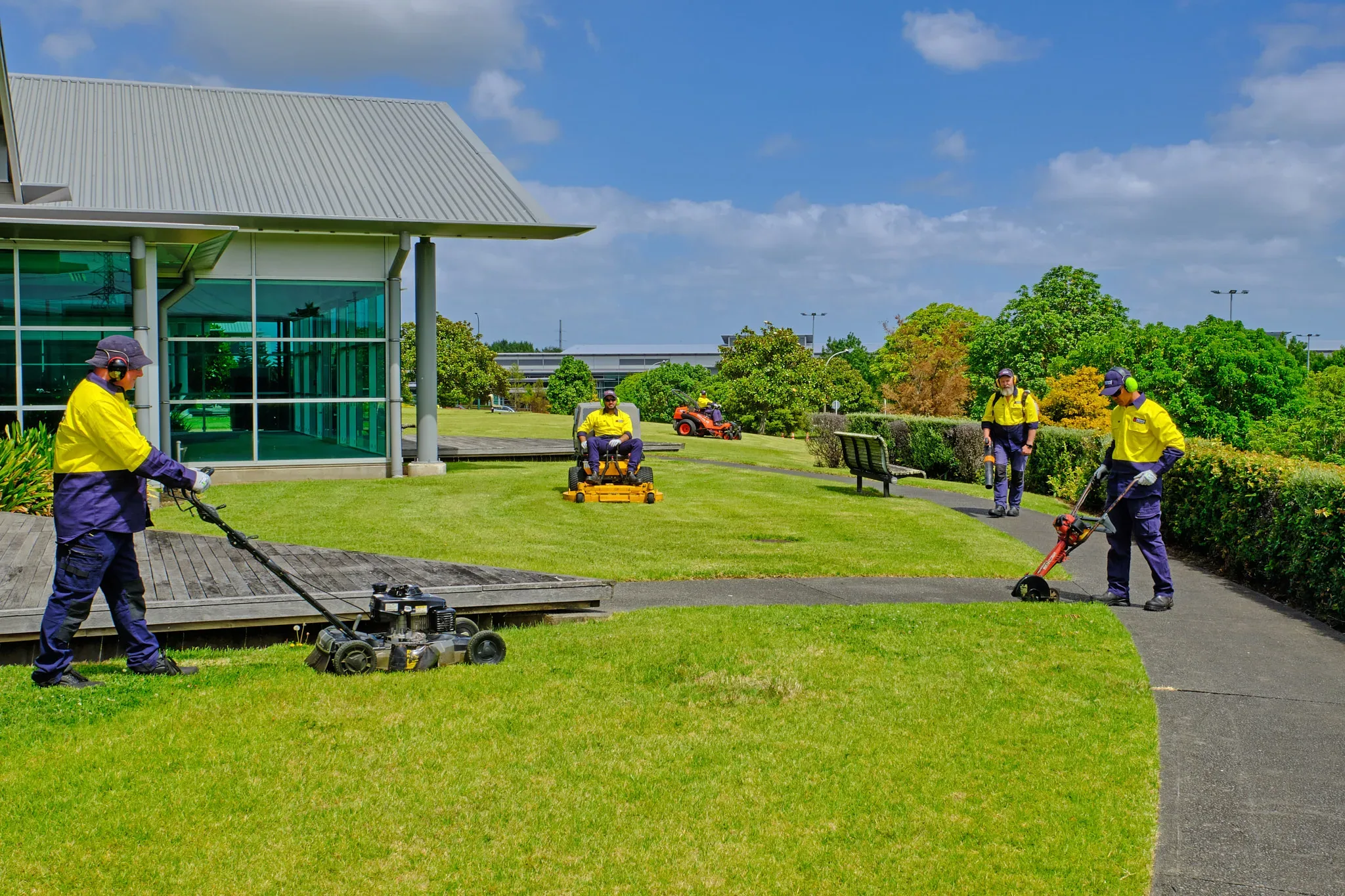 Holland Landscaping crew mowing and edging an Auckland commercial site