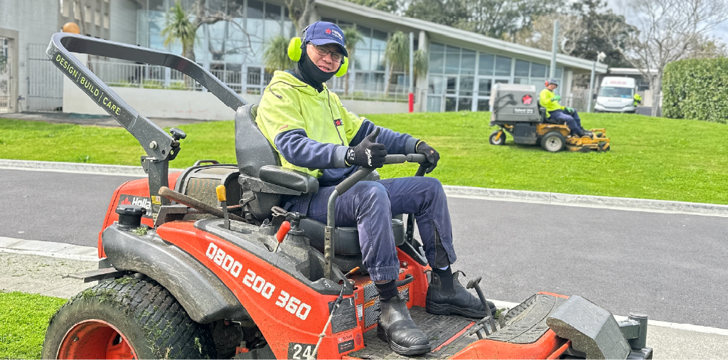 Holland landscaping crew operating riding lawn mower on an Auckland property.