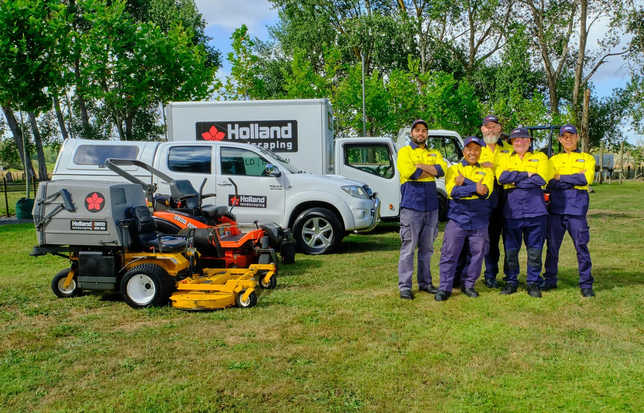 Holland Landscaping crew mowing at an Auckland retail site